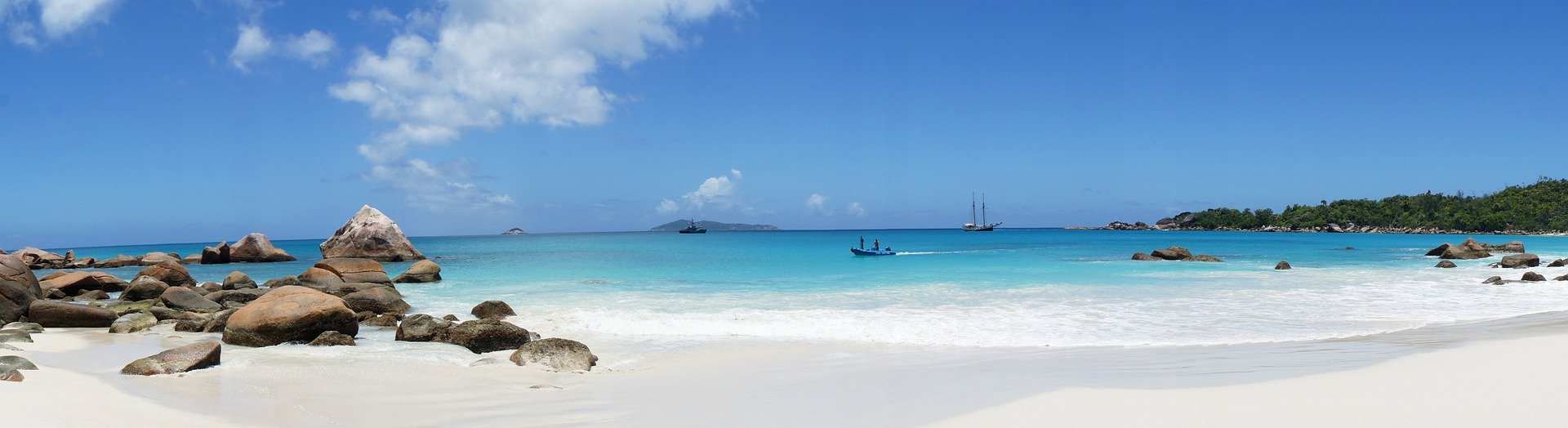 A Caribbean beach with boats in the water 