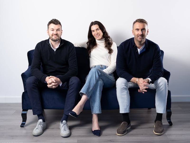 three people sat on a sofa