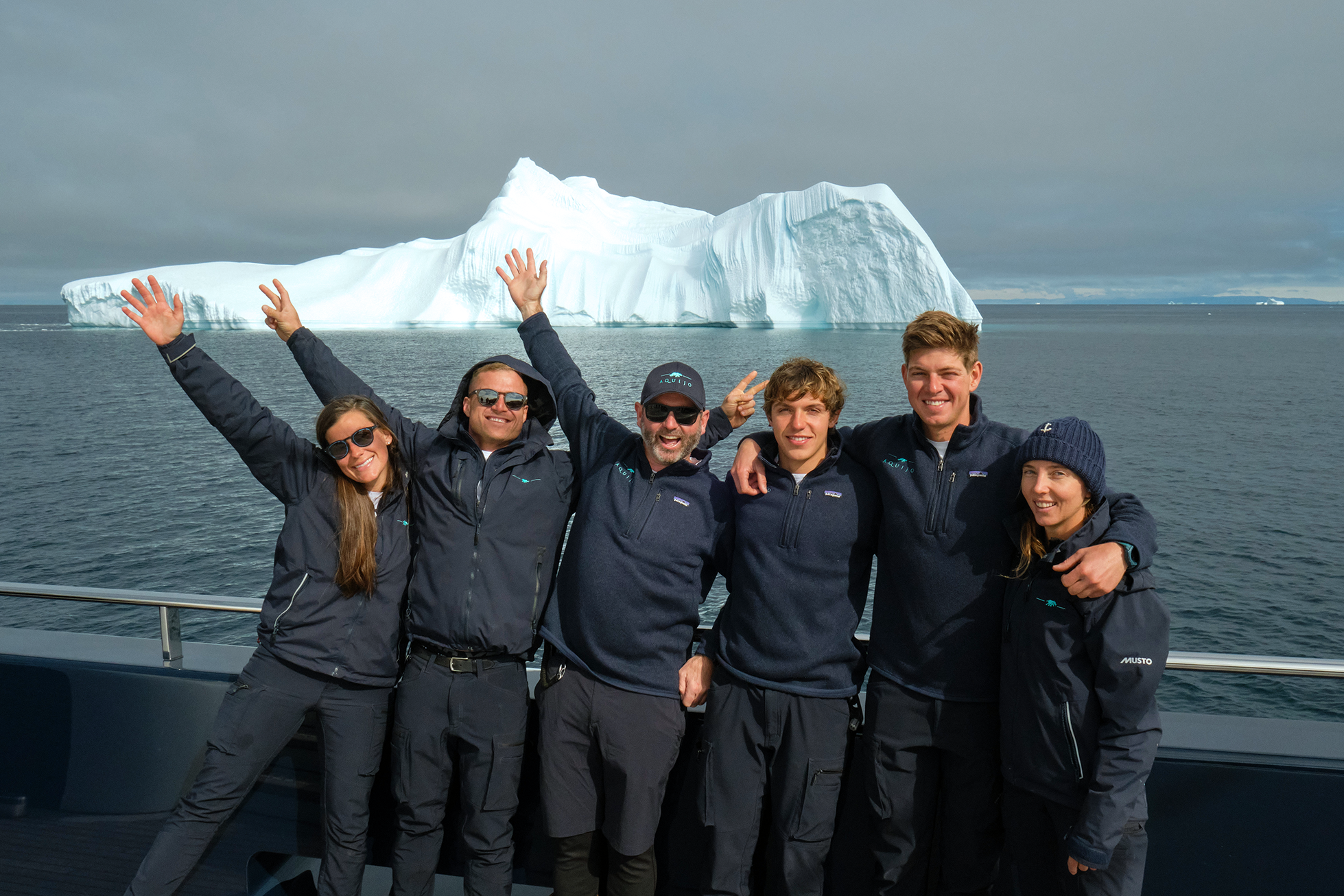 Crew of the Sail Yacht AQuiJo posing in front of an iceberg